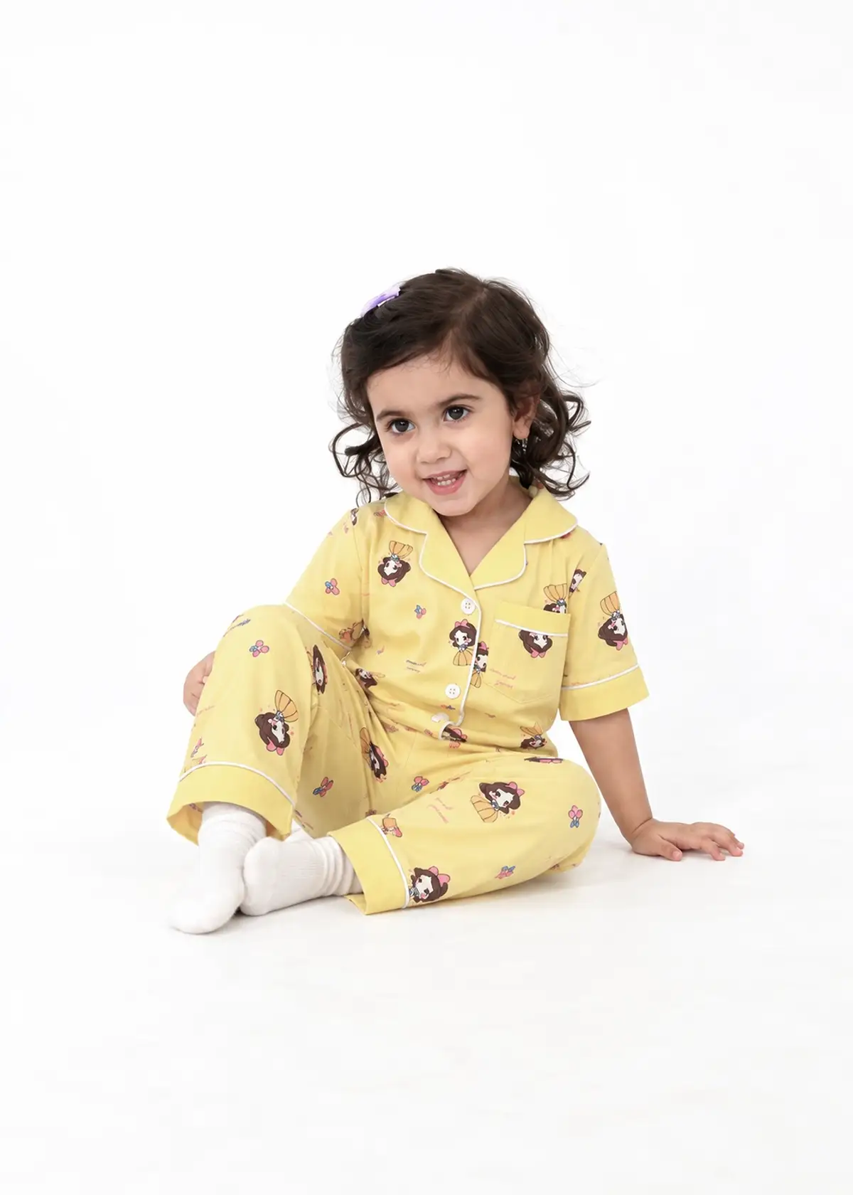Girl sitting in Lemon Princess half sleeve nightwear, yellow with princess print